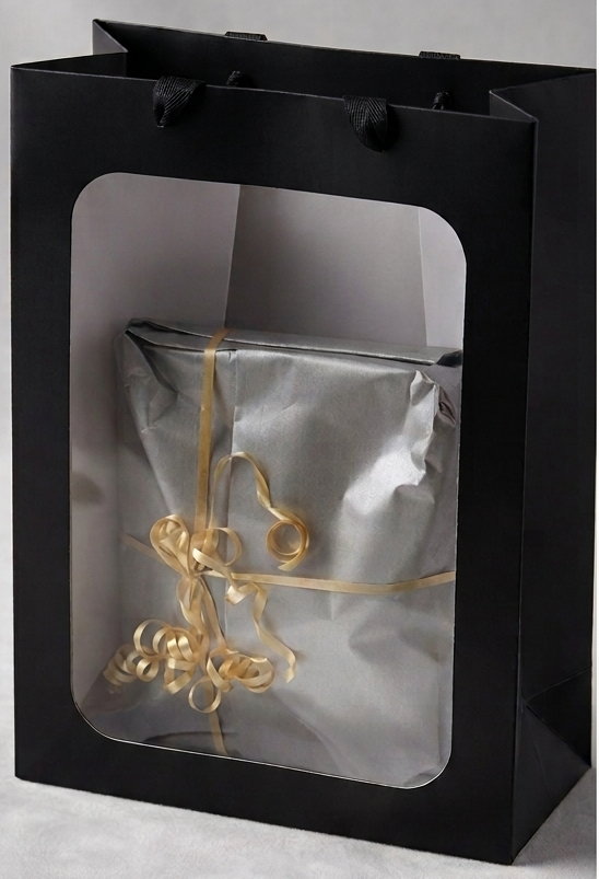 Premium gift wrapping — silver tissue with a gold ribbon bow in a black gift bag